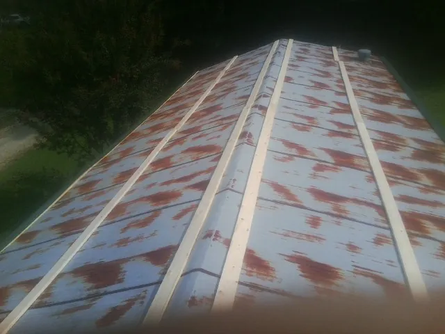 Rusted metal roof panels with new wood purlins before replacement — Storm Damage Roof Repair in Hugo by Roofing Brothers