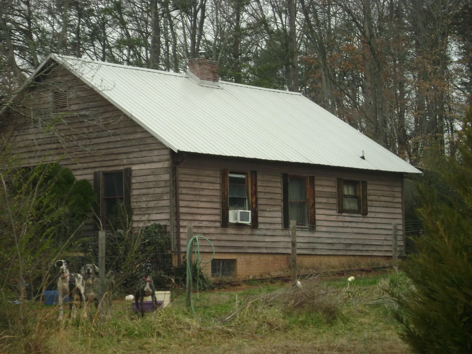 White metal roof on an old wood sided farmhouse, from a Metal Roof Installation job in Hugo