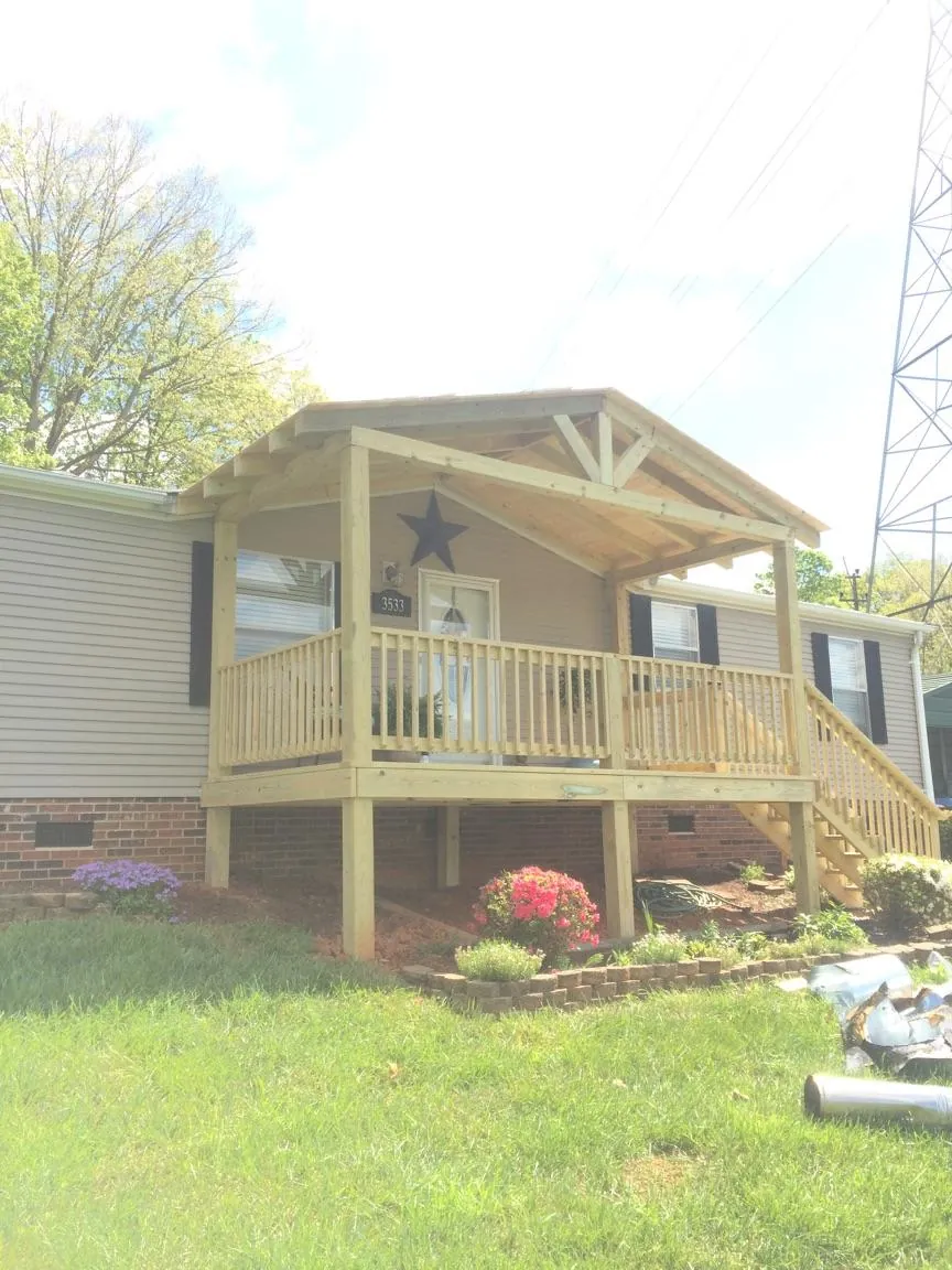 New gabled porch roof and deck railing added to a ranch home in Hugo